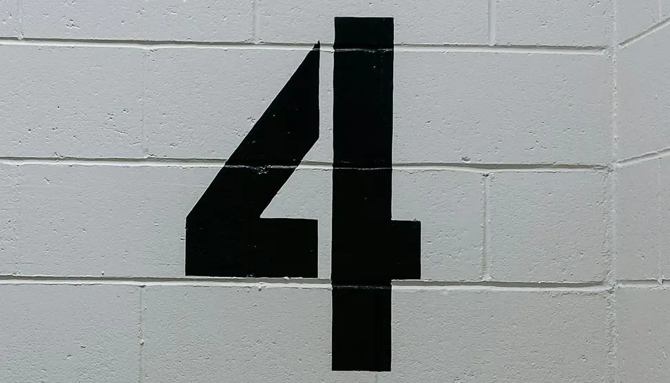 black arrow sign on white brick wall